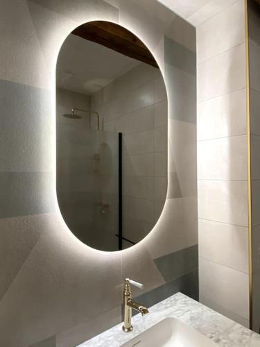 une salle de bain avec un lavabo et un miroir dans l'établissement Le petit écolier Hyper-centre Proxi gare-plage, à Dieppe