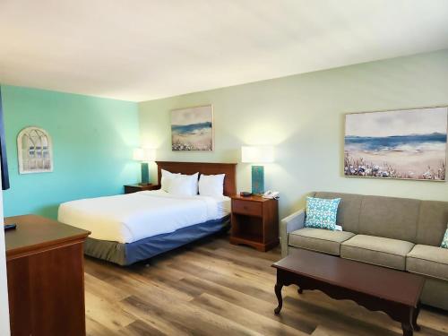 a hotel room with a bed and a couch at Inn at the Waterpark in Galveston