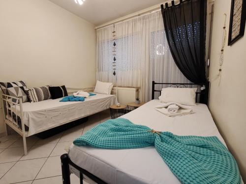 een slaapkamer met 2 bedden en een raam bij Thalia Luxury Apartment in Kavala