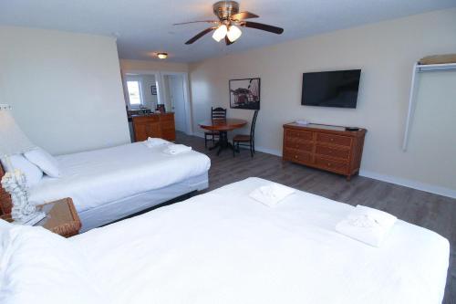 a hotel room with two beds and a flat screen tv at Fin 'N Feather Waterside Inn by Kees Vacations in Nags Head