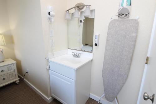 ein Bad mit einem Waschbecken und einem Spiegel in der Unterkunft Fin 'N Feather Waterside Inn by Kees Vacations in Nags Head