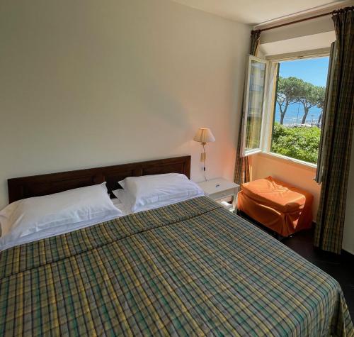 una camera con un letto e una grande finestra di Hotel Beau Rivage ad Alassio