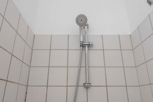 La salle de bains est pourvue d'une douche et de carrelage blanc. dans l'établissement NEW charming apt in City Center, à Copenhague