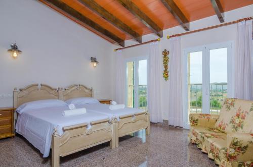ein Schlafzimmer mit einem Bett und einem Stuhl und Fenstern in der Unterkunft Sa Montanyeta in Manacor