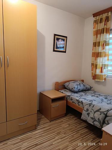 a small bedroom with a bed and a cabinet at 3-Bedroom NewHome in Mostar