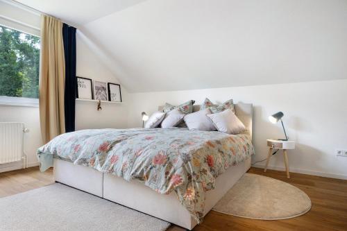 a white bedroom with a large bed with pillows at Ferienwohnung in Lüneburg in Lüneburg
