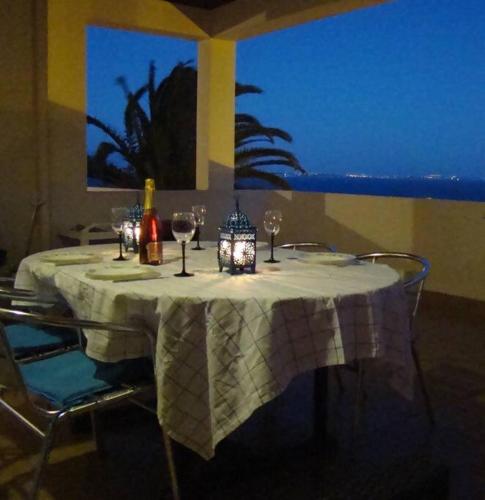 a table with wine glasses and a lantern on it at Lagos Love Bay - sea view in Lagos