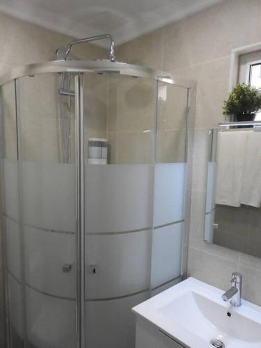 a bathroom with a glass shower and a sink at Lagos Love Bay - sea view in Lagos