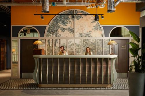 two women sitting at a bar in a lobby at Hotel Indigo Coventry by IHG in Coventry