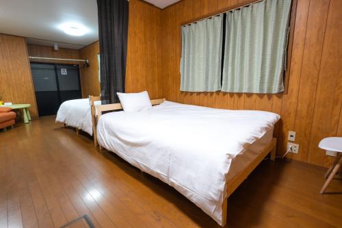 a bedroom with two beds and a window at 7House in Tokyo