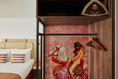 a bedroom with a painting of a woman and a horse at Hotel Indigo Coventry by IHG in Coventry