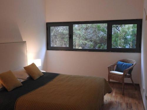 - une chambre avec un lit, une chaise et deux fenêtres dans l'établissement Lagos Factory Green, à Lagos