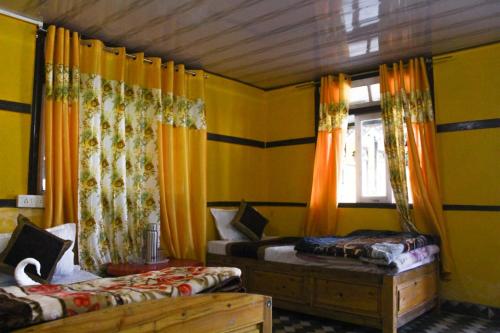 Cette chambre jaune comprend 2 lits et une fenêtre. dans l'établissement Heaven valley home stay, à Pedong