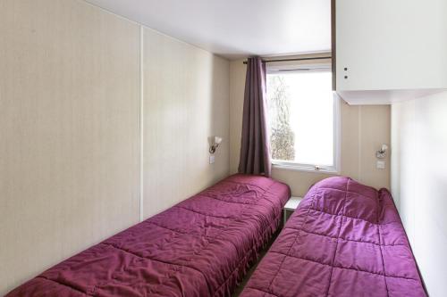 羅科比列爾的住宿－Camping 3* Les Templiers，紫色毯子间内的两张床