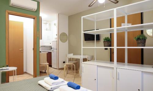 ein Schlafzimmer mit weißen Schränken und ein Zimmer mit einem Tisch in der Unterkunft Nel centro di Desenzano in Desenzano del Garda