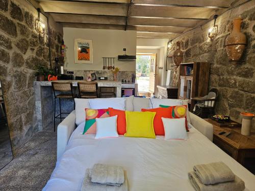 - une chambre avec un lit blanc et des oreillers colorés dans l'établissement Ancienne cave à vin rénovée, à Pianottoli-Caldarello