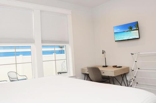 a white bedroom with a desk and a window at Reel Blessed by Pristine Properties Vacation Rentals in Saint Joe Beach