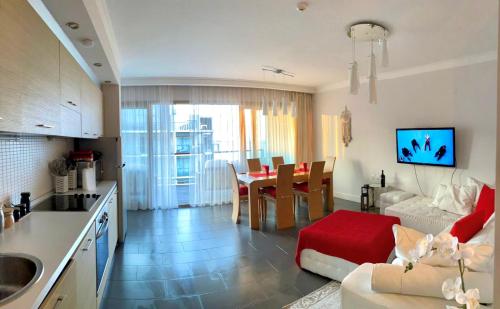 eine Küche und ein Wohnzimmer mit einem Sofa und einem Tisch in der Unterkunft Sea view Penthouse (YooBulgaria) in Obsor