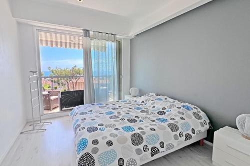 une chambre blanche avec un lit et une grande fenêtre dans l'établissement L'Horizon, à Nice