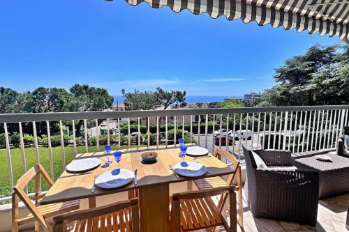 d'un balcon avec une table en bois et des chaises. dans l'établissement L'Horizon, à Nice
