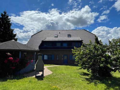 a house with a roof on top of a yard at Ferienwohnung 11 am Selliner See in Ostseebad Sellin