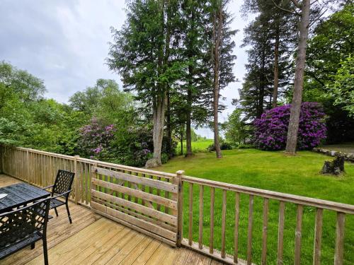a wooden deck with a table and a bench on it at Ard Veich Estate - Panoramic Highland Sea Views with private beach and woodland in Port Appin