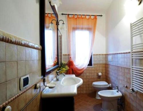 a bathroom with a sink and a toilet and a window at Agriturismo Le Rose in Pescia Romana