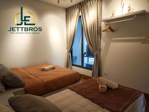 a hotel room with two beds and a window at Teega Residence By JettBros Iskandar Puteri in Nusajaya
