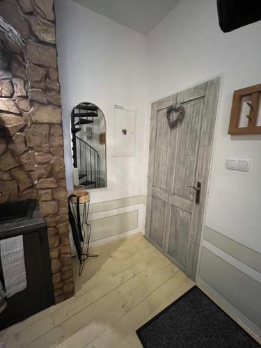 a hallway with a wooden door and a stone wall at Apartmán siedmy div in Banská Štiavnica