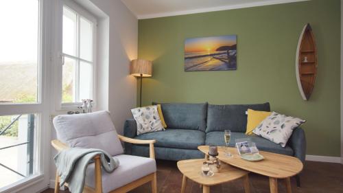 a living room with a couch and a table at Haus Seeblick mit 9 Wohnungen in Alt Reddevitz