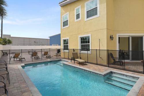 a swimming pool with chairs and a building at PRIVATE POOL Fortebello Beachside 158 in Indian Harbour Beach