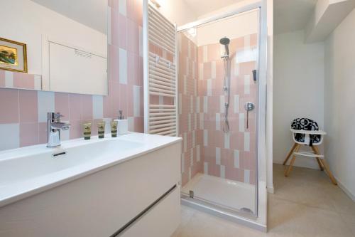 a bathroom with a sink and a shower with pink tiles at Casa Mavi in Corte Franca