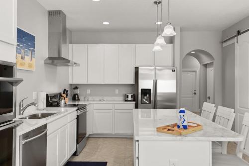 a kitchen with white cabinets and stainless steel appliances at Fortebello Beachside 154 in Indian Harbour Beach