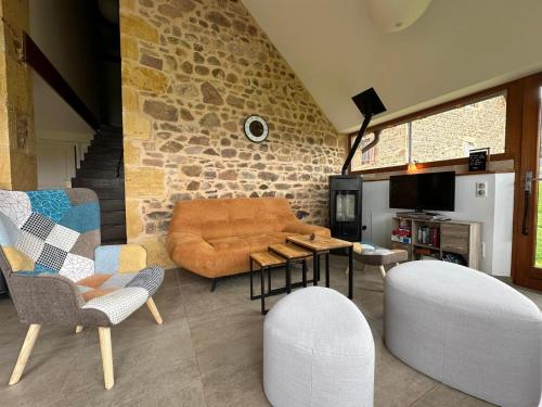 un salon avec un canapé et des chaises dans l'établissement Les Perruchons ancienne grange rénovée avec soin, à Ozolles