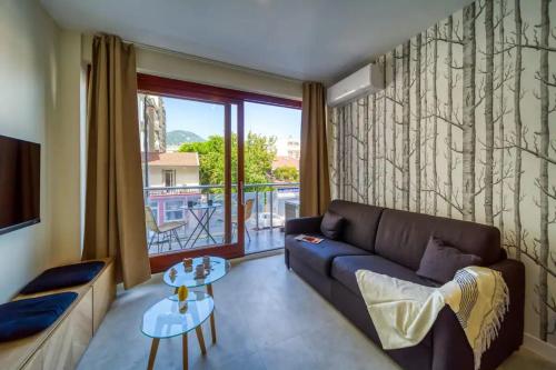 un salon avec un canapé et une grande fenêtre dans l'établissement #GR Le Joli Mallifaud, à Grenoble