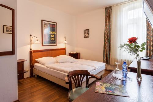 a hotel room with a bed and a table at Landhotel Zur Linde in Verden