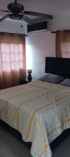 - une chambre avec un lit et un ventilateur de plafond dans l'établissement Villa José al, à Santiago de los Caballeros