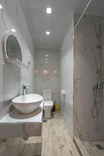 a white bathroom with a sink and a toilet at Laconia Domus - Plytra in Plytra