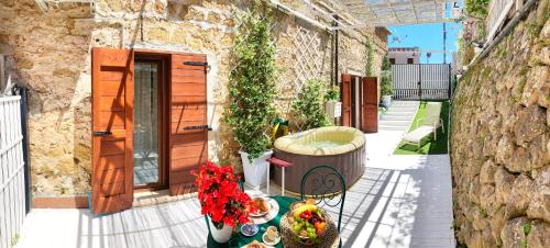 a patio with a tub and flowers and a building at Circeii in San Felice Circeo