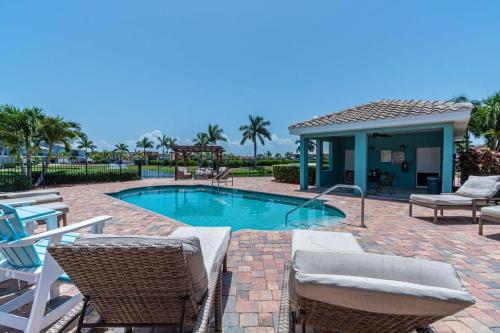 a patio with chairs and a swimming pool at Luxury Townhouse Minutes from Beach and Downtown in Indian Harbour Beach