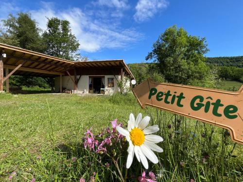 a sign in front of a field with a white flower at Gite de Mailhac in Loubières