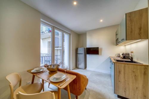 une cuisine avec une table et des chaises dans une pièce dans l'établissement #GS Le Beau Berthelot, à Grenoble