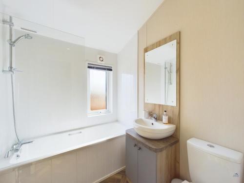 a white bathroom with a sink and a mirror at E7 Roebeck Country park in Ryde