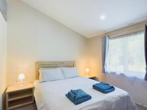 E7 Roebeck Country park في رايد: غرفة نوم عليها سرير وفوط زرقاء
