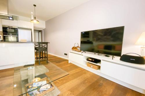 un salon avec une grande télévision à écran plat dans l'établissement #GU Le Diodore T2 Design Hyper-centre, à Grenoble