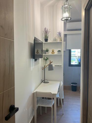 a small white desk in a room with a lamp at GARDEN HOUSE Madrid in Madrid