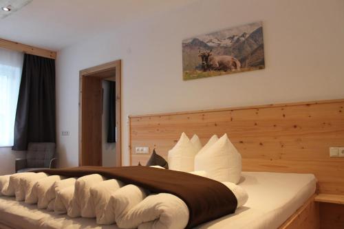 1 dormitorio con 1 cama grande y cabecero de madera en Haus Hermine, en Umhausen