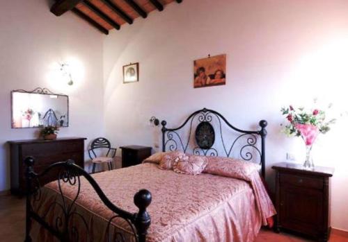 a bedroom with a black bed with a pink blanket at Agriturismo Le Rose in Pescia Romana