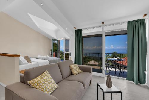 a living room with a couch and a view of the ocean at Stonehouse Residence in Makarska