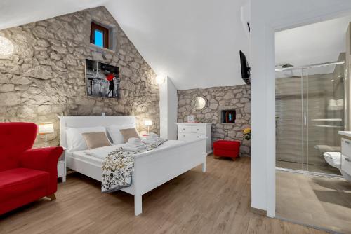 a bedroom with a white bed and a stone wall at Stonehouse Residence in Makarska